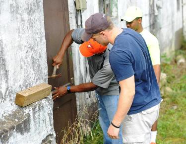 Defensive coordinator Mike Clowney puts up a door with assistance from linebacker Brandon Staton